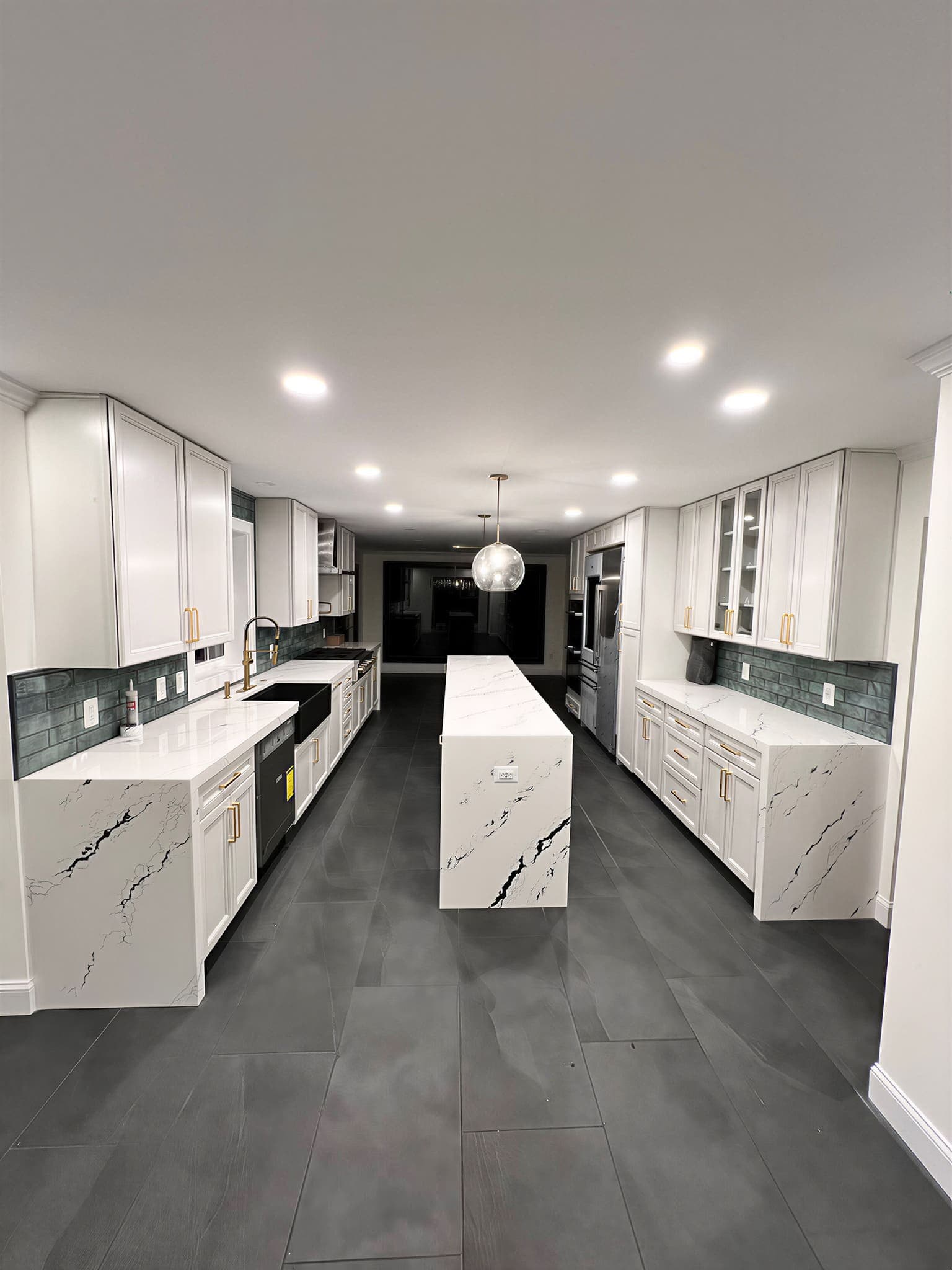 After renovation, bright luxury kitchen with white shaker cabinets, quartz countertops, and green tile backsplash, Hillington