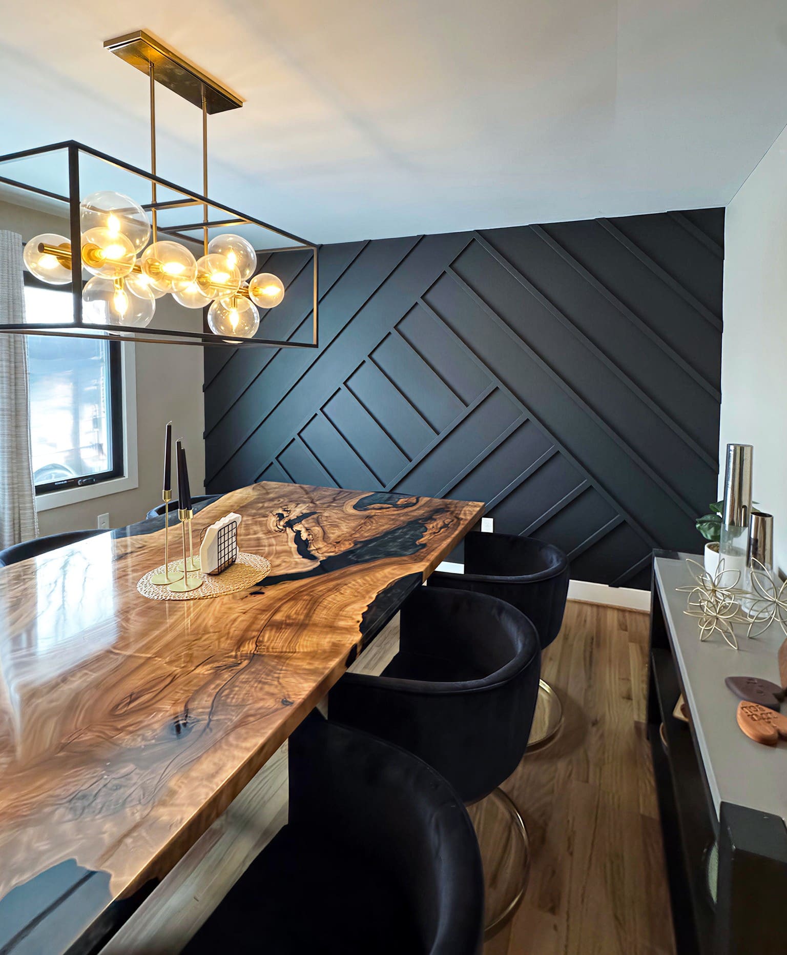 Live-edge wood dining table with black herringbone accent wall