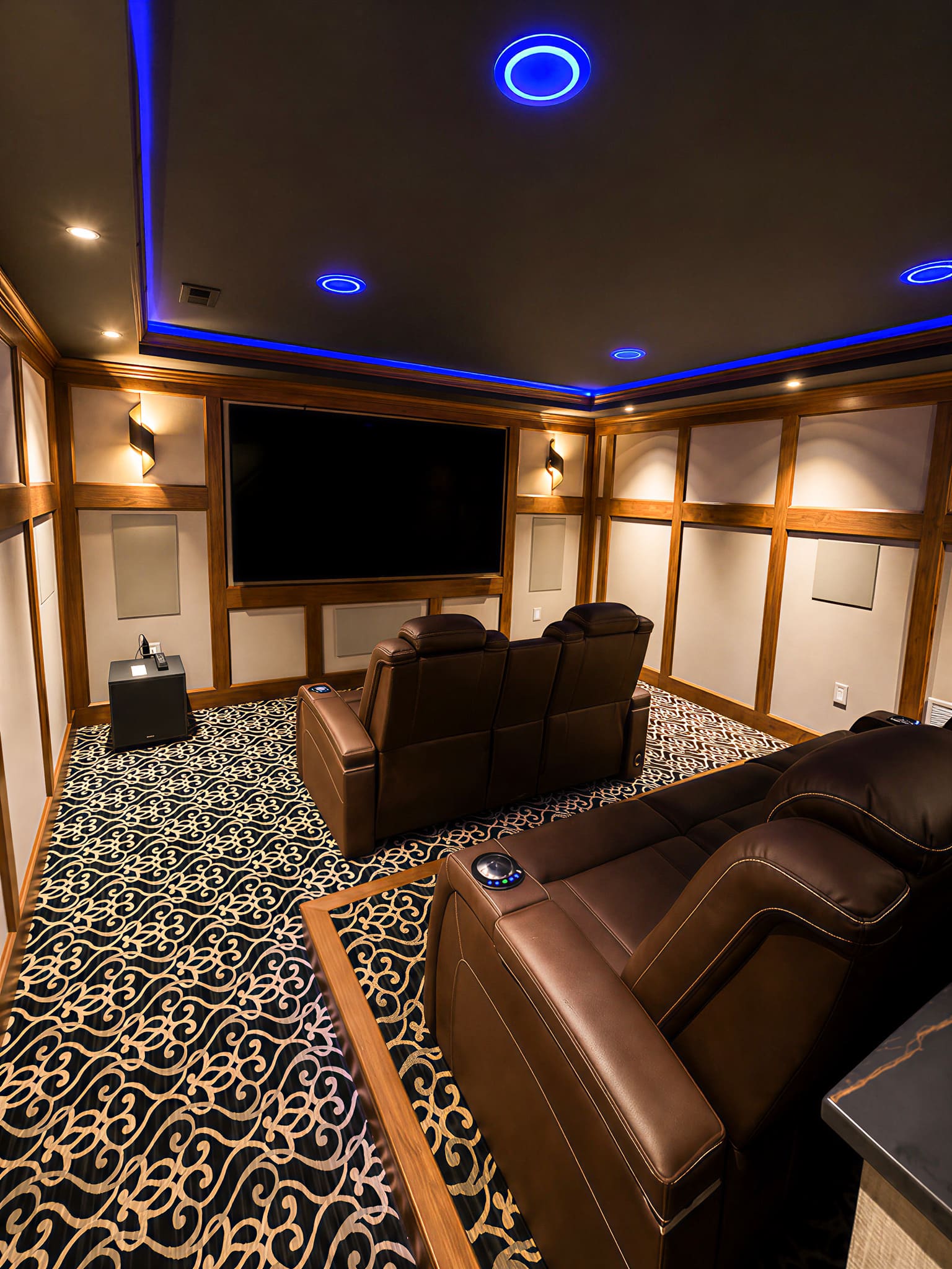 Home theater with reclining leather seating and blue accent lighting