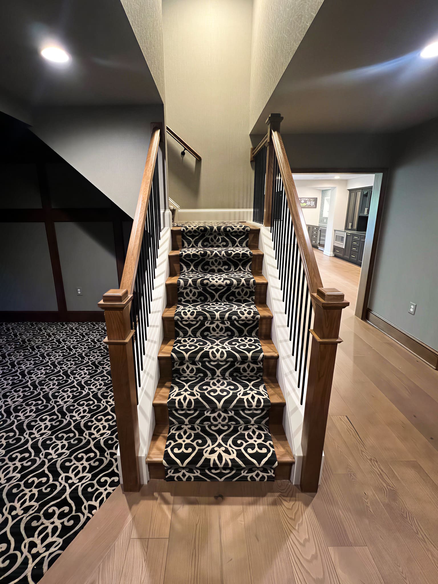 Staircase with custom black and white patterned runner carpet