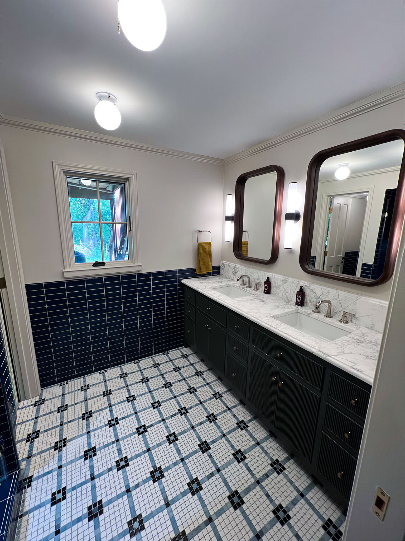 Navy blue double vanity bathroom with mosaic tile floor