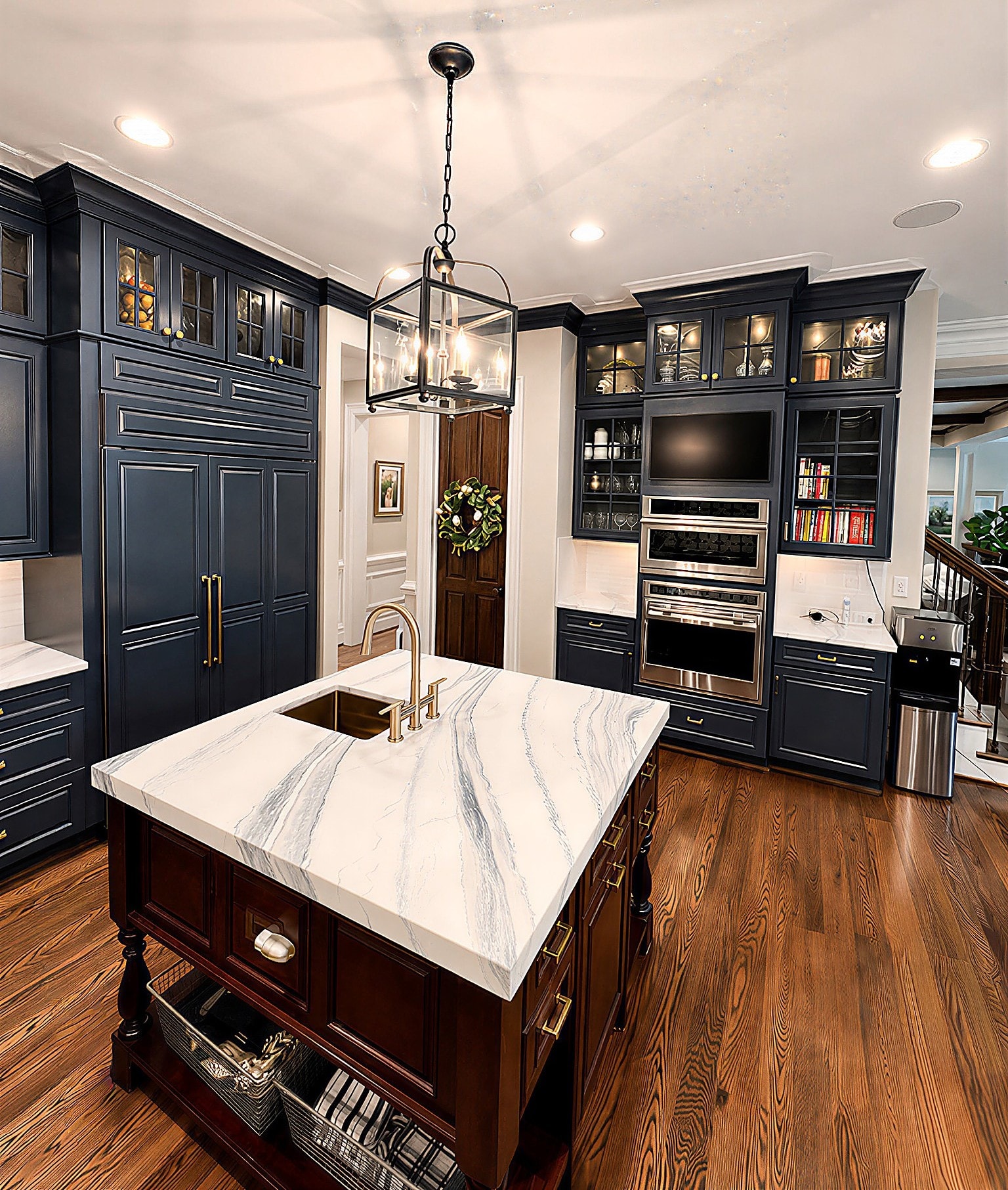 Navy blue kitchen island with marble countertop and brass fixtures