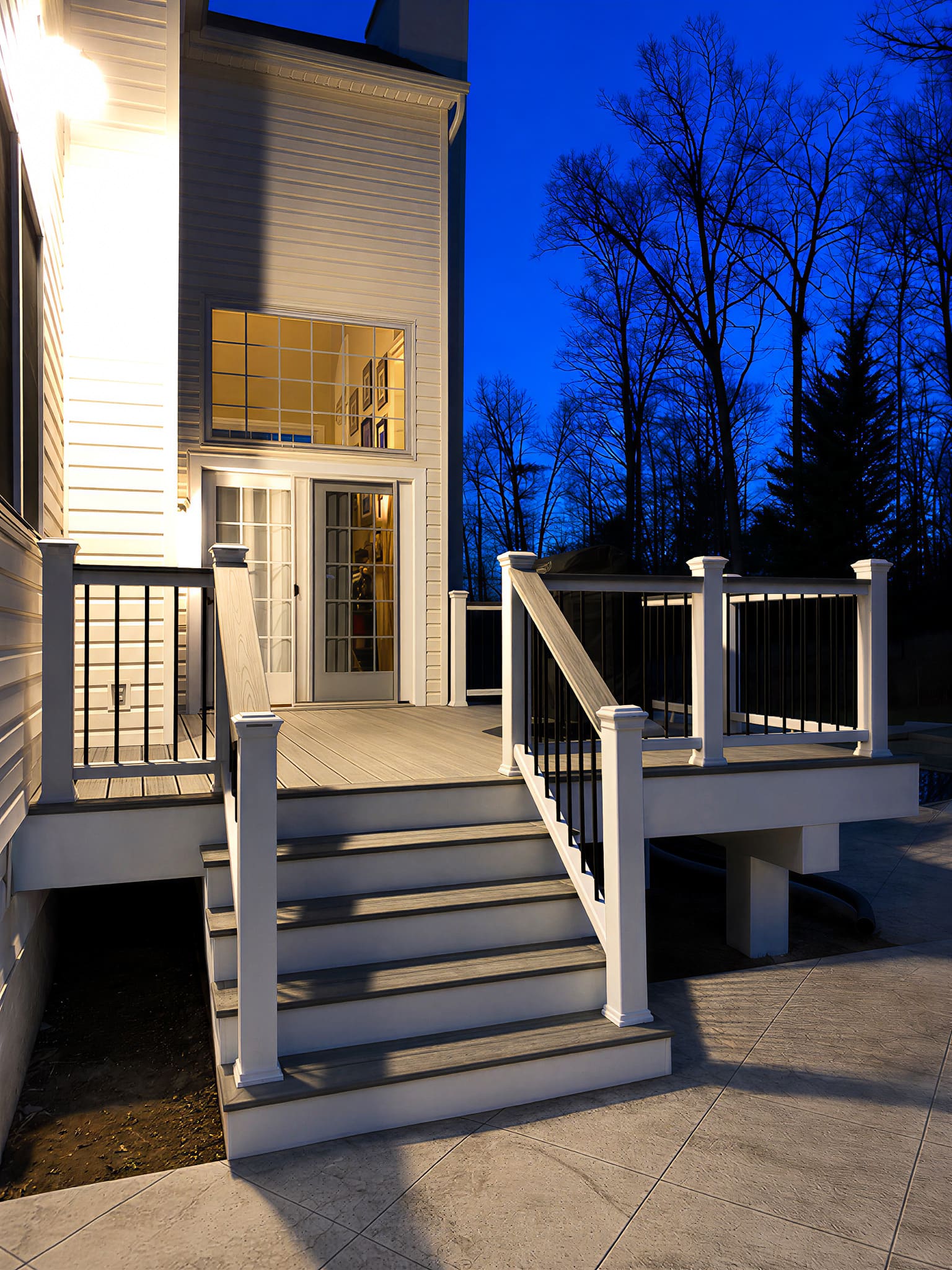 White deck illuminated at dusk with warm interior lighting