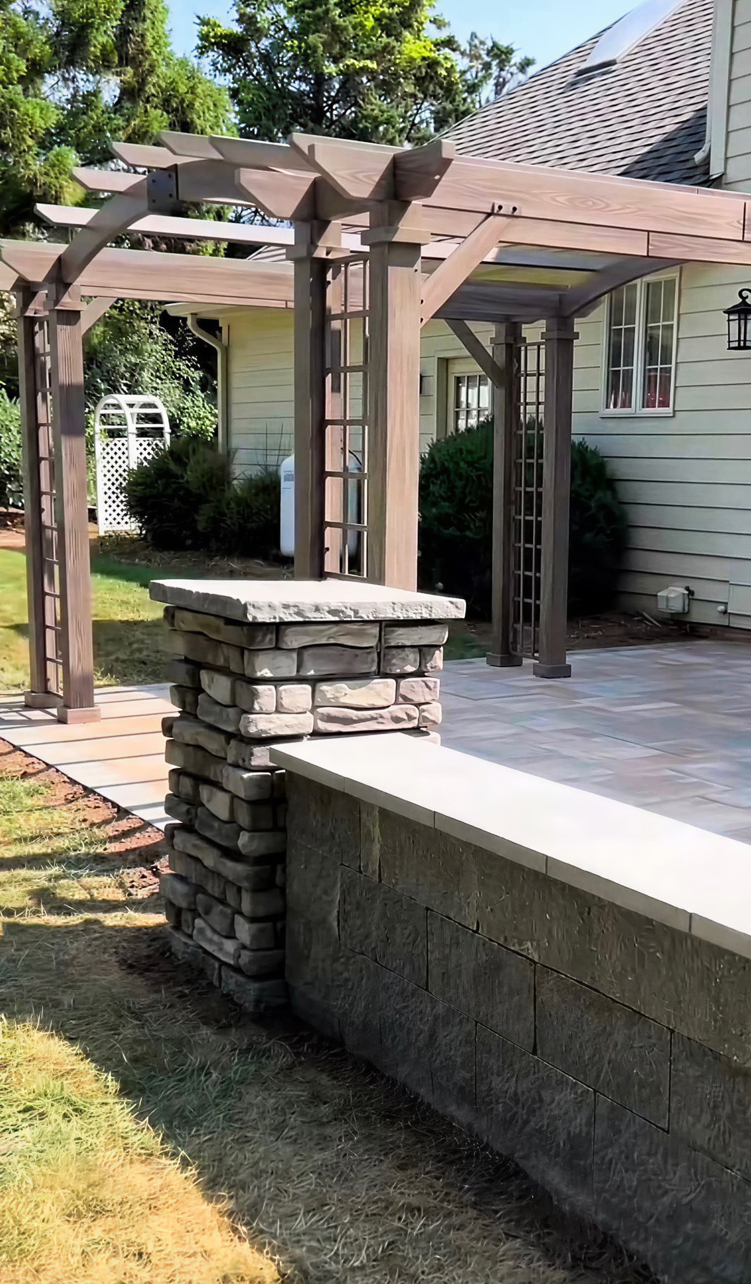 Custom wood pergola alongside a natural stacked stone accent wall