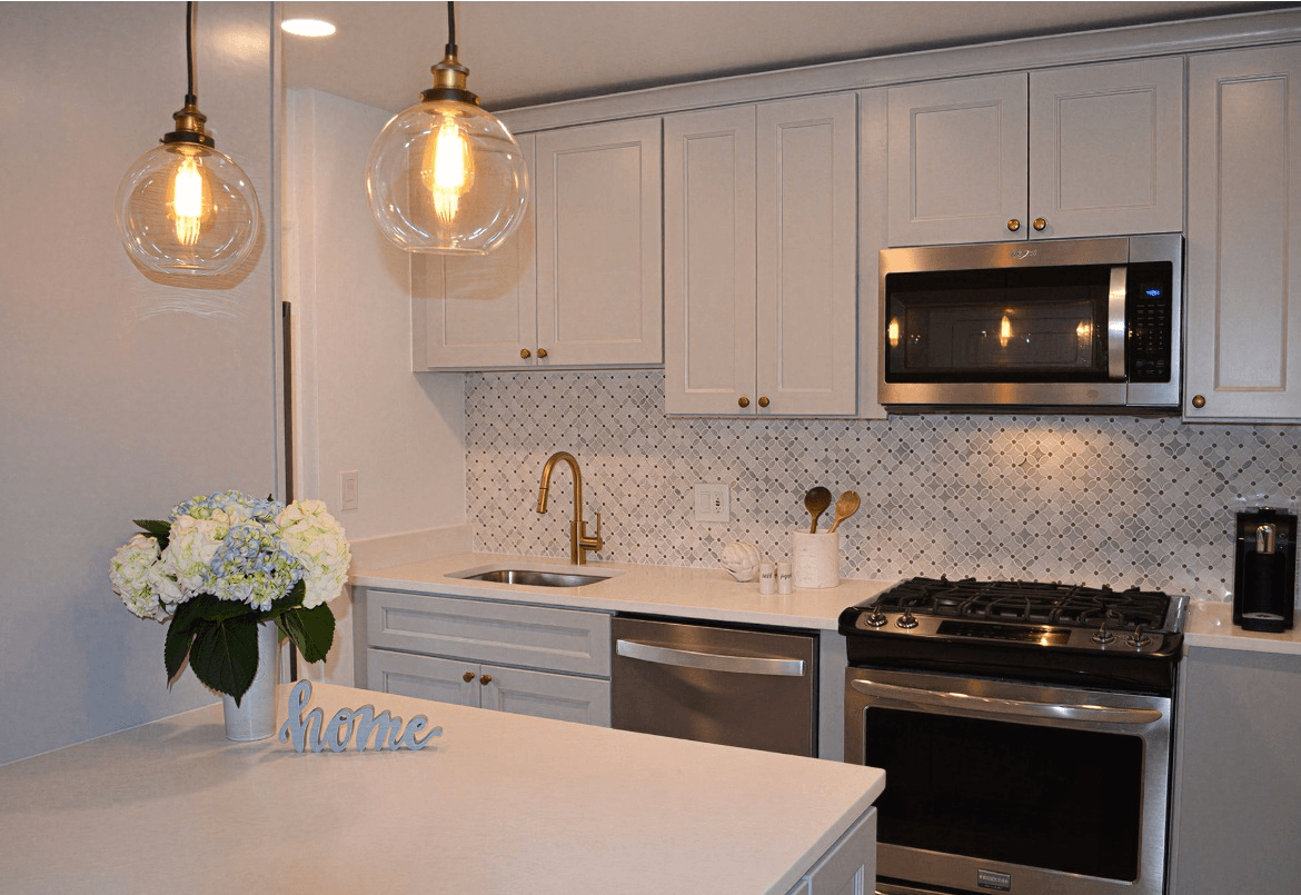 High-end modern kitchen renovation, white shaker cabinets, quartz countertops